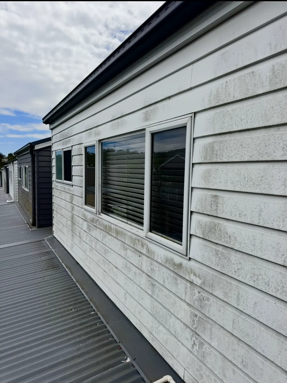 Professional pressure washing a home exterior in Newcastle
